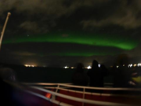 northern lights and passengers on a boat