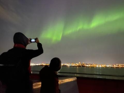 northern lights and passengers on a boat