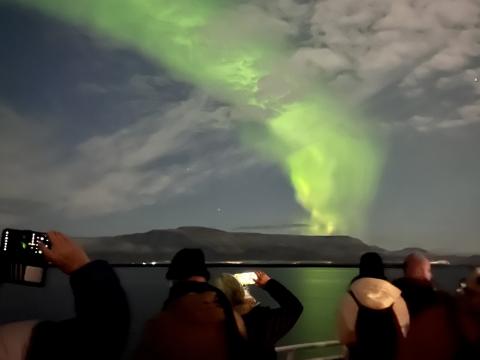northern lights and passengers on a boat