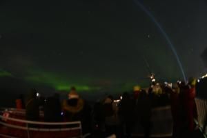 northern lights and passengers on a boat