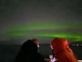 northern lights and passengers on a boat