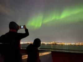 northern lights and passengers on a boat