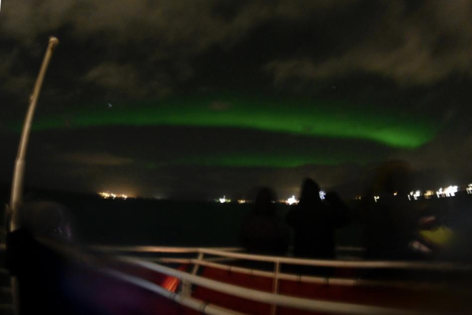 northern lights and passengers on a boat