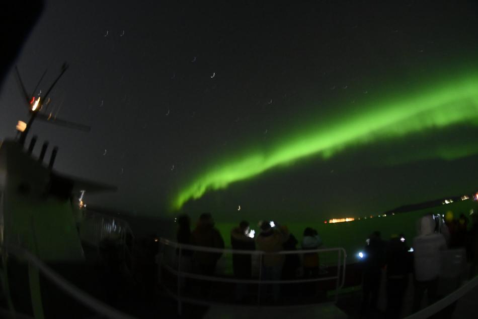 northern lights and passengers on a boat