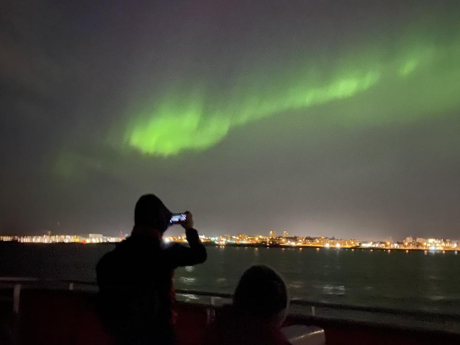 northern lights and passengers on a boat