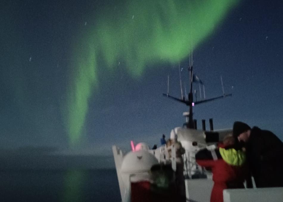 northern lights and passengers on a boat