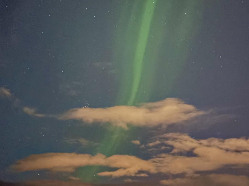 northern lights amongst clouds in the night sky