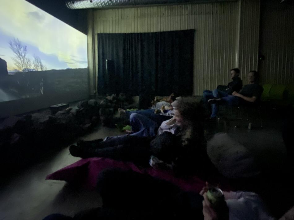 Guides sit down and watch a northern lights movie.