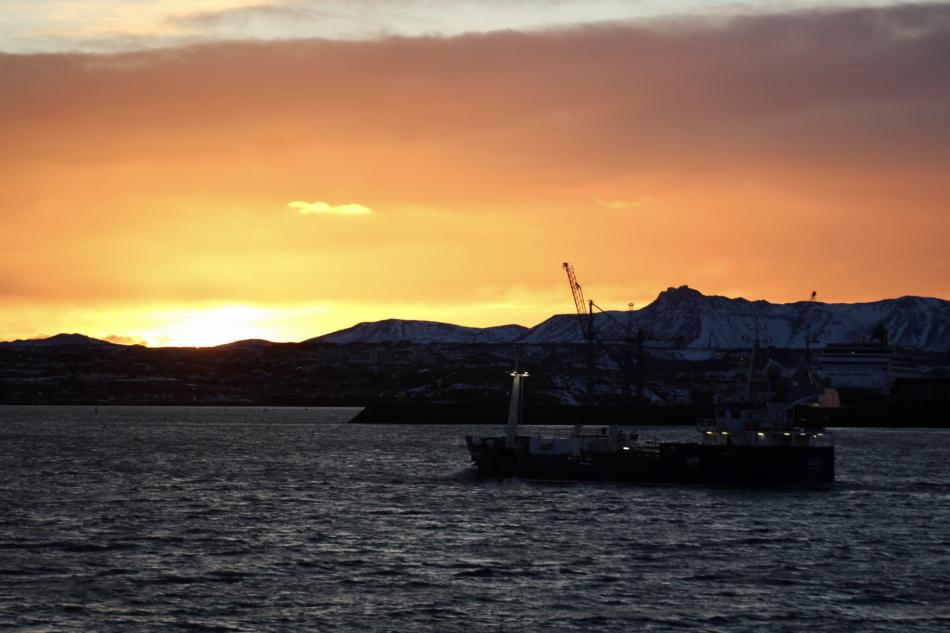 fishing boat off reykjavik sailing into the sunrise